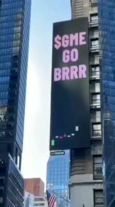 Prominent $GME GO BRRR advertisement illuminating the heart of Times Square on a massive digital billboard.